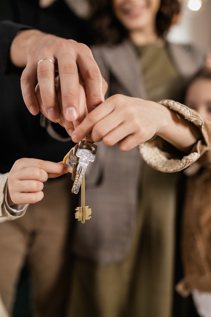 Close-up of a family holding house keys, symbolizing home ownership.