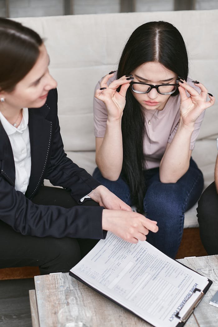 menu-01 Focused businesswomen discuss contract details while reviewing important documents in an office setting.